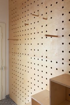 the wall is made out of plywood and has holes on it, as well as shelves