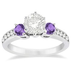 an engagement ring with two purple stones on the side