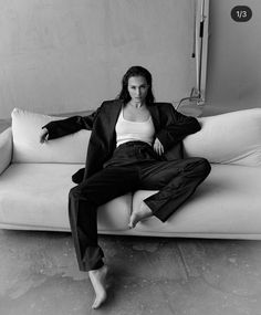 a woman sitting on top of a white couch