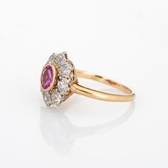 Stylish antique Edwardian pink sapphire & diamond cluster ring crafted in 14k yellow gold (circa 1900s to 1910s). One centre set pink sapphire is estimated at 0.50 carats, accented with eight estimated 0.15 carat old mine cut diamonds. The total diamond weight is estimated at 1.20 carats (estimated at I-J and SI1-I1 clarity). The sapphire is in very good condition and free of cracks or crisps.   The classic cluster design highlights a halo of diamonds surrounding the vibrant and lively pink sapp Old Cut Diamond Ring, Classic Pink Cluster Ring For Formal Occasions, Classic Pink Cluster Ring With Center Stone, Classic Ruby Ring With Rose Cut Diamond Cluster, Classic Pink Diamond Cluster Ring, Classic Pink Cluster Ring With Halo Setting, Classic Pink Ruby Ring With Halo Setting, Classic Pink Cluster Ring With Prong Setting, Vintage Ruby Cluster Ring With Center Stone