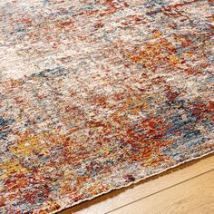 a multicolored area rug with wooden flooring and wood floors in the background