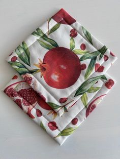 two napkins with pomegranate designs on them