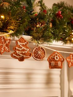 gingerbread ornaments hanging from a fireplace mantel