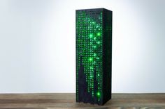 a tall wooden block with green lights on it