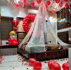 a bedroom decorated for valentine's day with red balloons