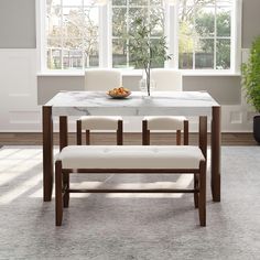 a dining table with four chairs and a bowl of fruit on it