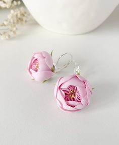 two pink flowers sitting on top of a white table