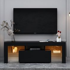 a flat screen tv mounted to the side of a wall next to a vase with flowers