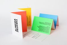 three different colored business cards sitting next to each other on top of a white surface