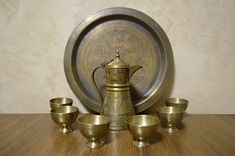 an antique brass tea set on a wooden table