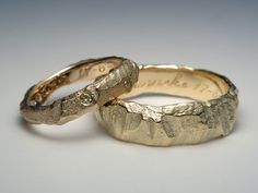 two gold wedding bands that have been made to look like they are in the shape of leaves