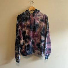 a tie dyed hoodie hanging on a wall