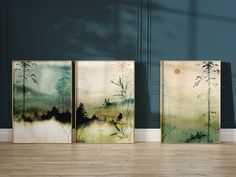 three paintings on the wall in an empty room with wood flooring and blue walls