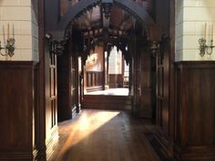 an empty hallway with wooden floors and arches