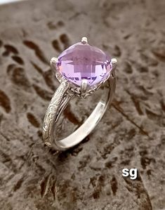 One of a kind, genuine lavender/rose de France quartz gemstone ring. Beautiful purple/pink color.  9 millimeters by 9 millimeters cushion cut, earth mined quartz stone, set in solid sterling silver.   Hand engraved, filigree, scroll setting ring mount. Purple Pink Color, Lavender Quartz, Violet Rose, Ring Mountings, Lavender Roses, Quartz Rose, Quartz Stone, Victorian Style, Hand Engraving