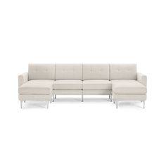 a white sectional couch and ottoman on a white background