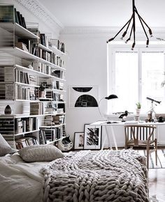 a living room filled with lots of furniture and bookshelves