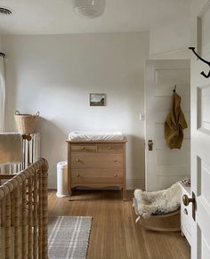 a baby crib in the corner of a room next to a dresser and door