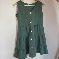 This Olive Green Colored Dress Is Nwot. It Is Listed As A Size Medium But It Runs A Bit Big (So It Fits Like A Large). The Bottom Of The Dress Has Three Different Layers That Flare Out! Disclaimer: All Of The Pictures Are Taken With The Same Camera And With The Flash On, However The Color Looks A Bit Different Depending On The Background. I Would Say The Color Is Closer To The Olive Green Than The More Teal Color! Summer Mini Dress With Buttons For Vacation, Fitted Beach Sundress With Buttons, Fitted Sundress With Buttons For Beach, Fitted Button Sundress For Beach, Fitted Buttoned Sundress For The Beach, Summer Sundress With Button Closure For Beach, Beach Sundress With Buttons, Mini Length, Beach Sundress With Buttons In Mini Length, Summer Beach Mini Dress With Button Closure