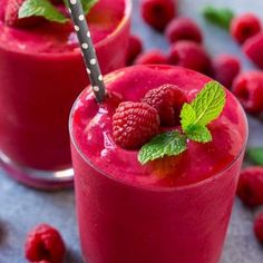 two glasses filled with raspberry smoothie and garnished with mint