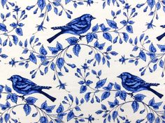 a blue and white wallpaper with two birds on the branches, one bird sitting on top of another branch