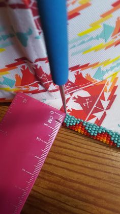 a piece of fabric being sewn on with a sewing needle and ruler next to it