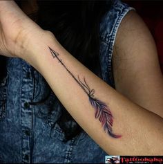 a woman's arm with an arrow tattoo on it