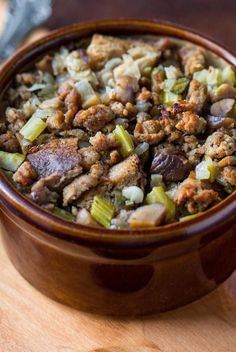 a wooden bowl filled with stuffing and vegetables