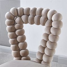 a chair made out of stones sitting in front of a wall