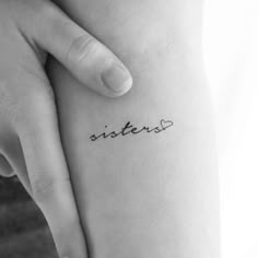 a person holding their arm with the word sisters written on it in cursive font