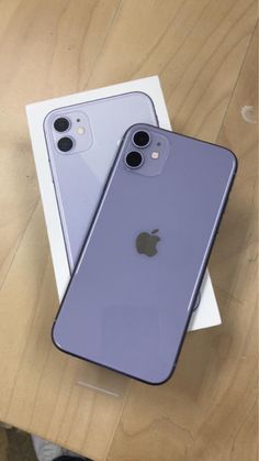 two new iphones are sitting next to each other on a table in front of a box