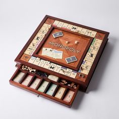 a monopoly board game in its wooden case with dices and pieces on the board