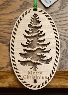 a wooden ornament with a christmas tree on it and a tag hanging from the side