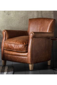 a brown leather chair sitting on top of a tiled floor