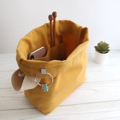 a yellow bag with a keychain hanging from it's side on a white table