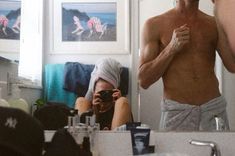 a shirtless man taking a selfie in front of a mirror with his reflection