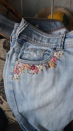 an old pair of jeans with embroidered flowers on them