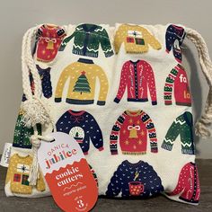 a handbag with ugly sweaters on it and a tag hanging from the front