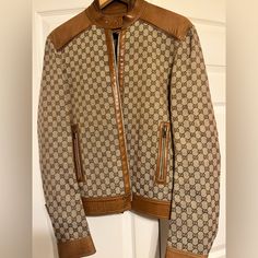 The Gg Motif Is A Subtle Nod To The Theme Of Reinvention That Appears Throughout The House's Narrative. First Used In The '70s, The Monogram Is An Evolution Of The Gucci Rhombi Designa Pattern From The '30s Archives. A Part Of The Aria Collection, It Appears Atop This Jacket With Leather Trims. Minor Signs Of Wear. Original Price: $ 4,500 Fitted Beige Gucci Outerwear, Gucci Designer Leather Outerwear, Gucci Fitted Leather Jacket For Fall, Fitted Gucci Beige Outerwear, Designer Leather Gucci Outerwear, Designer Gucci Leather Outerwear, Casual Fitted Gucci Outerwear, Gucci Brown Winter Outerwear, Gucci Beige Outerwear For Fall