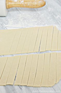 two pieces of bread sitting on top of a table next to a rolling pin and spatula