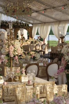 tables and chairs are set up for a wedding reception with floral centerpieces on them