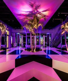 an indoor area with palm trees and purple lighting