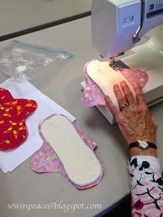 an older woman is using a sewing machine to sew on her hand and some fabric