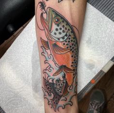 a colorful fish tattoo on the arm