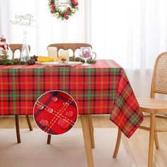 a plaid table cloth with red buttons on it and a christmas wreath in the background