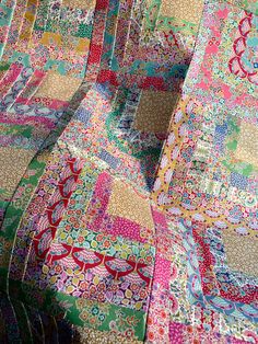 colorful patchwork quilts on display in a store