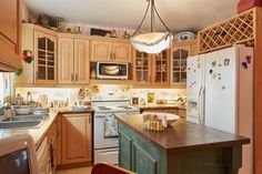 a kitchen filled with lots of wooden cabinets and white appliances, including a refrigerator freezer