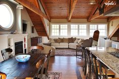 a living room filled with furniture and a fire place in the middle of a kitchen