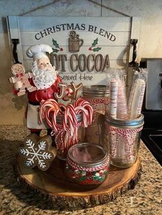 a santa clause sitting on top of a counter next to candy canes and cookies