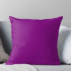 a purple throw pillow sitting on top of a couch